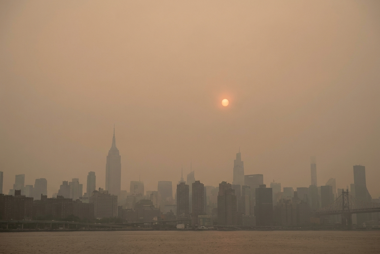A major U.S. city skyline under heavy orange wildfire smoke haze